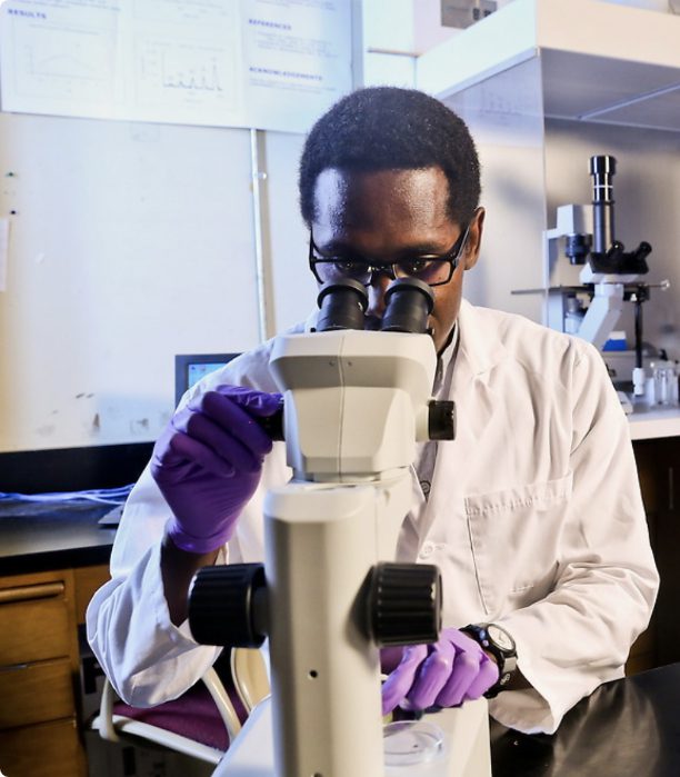 Jackson State University student using a microscope in a research lab